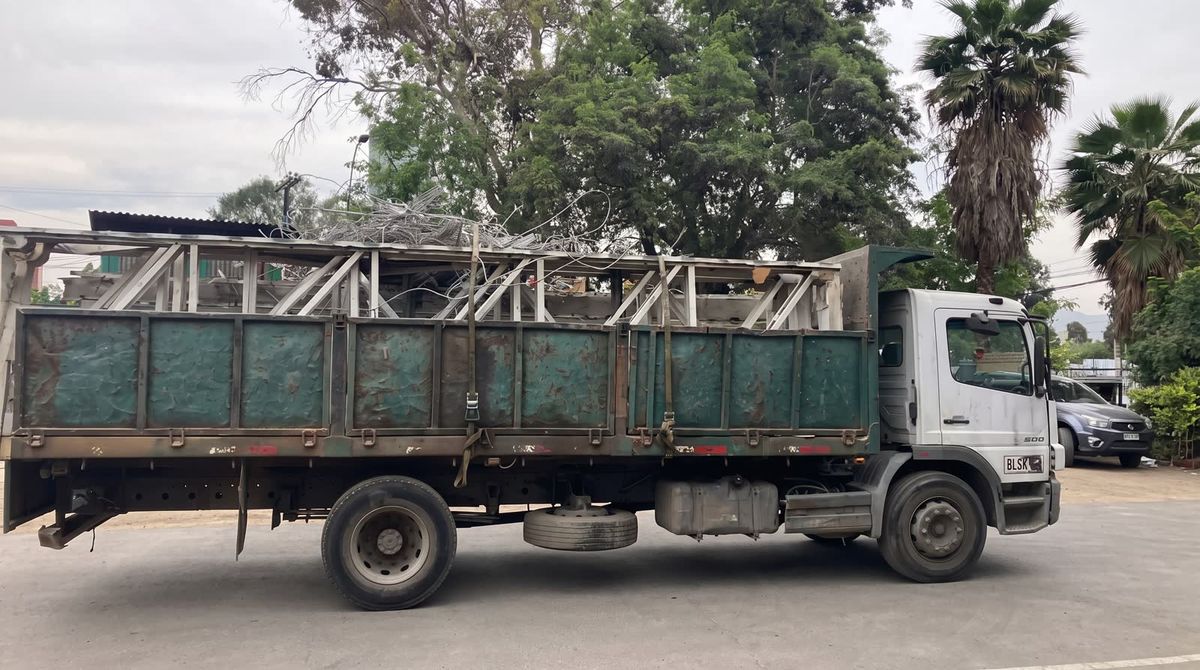Camión de la flota de Los Maitenes SpA cargado con estructuras metálicas durante un retiro en las instalaciones de un cliente.